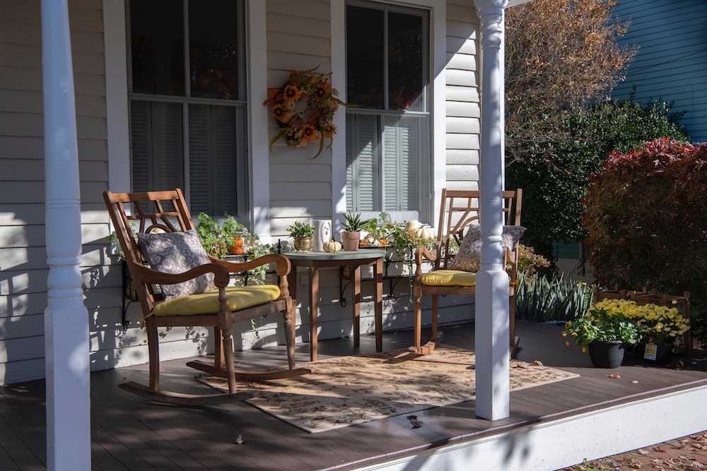 front porch with table and chairs and fall decorations